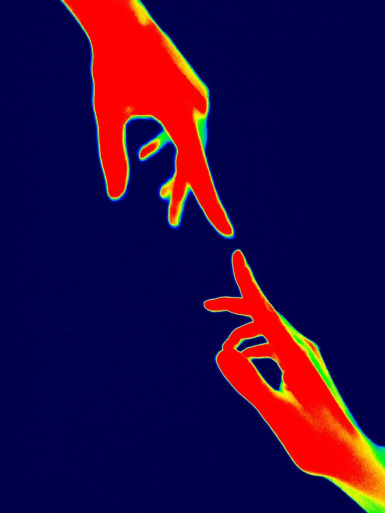 thermal image of 2 hands pointing at each other