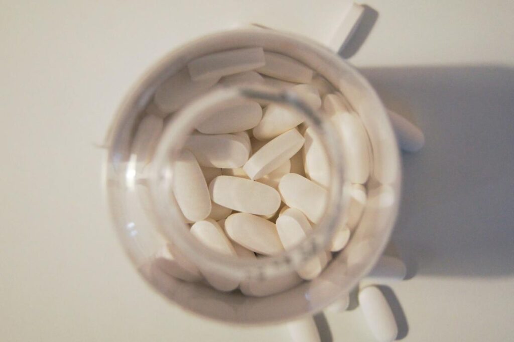 calcium pills in clear bottle with lid open